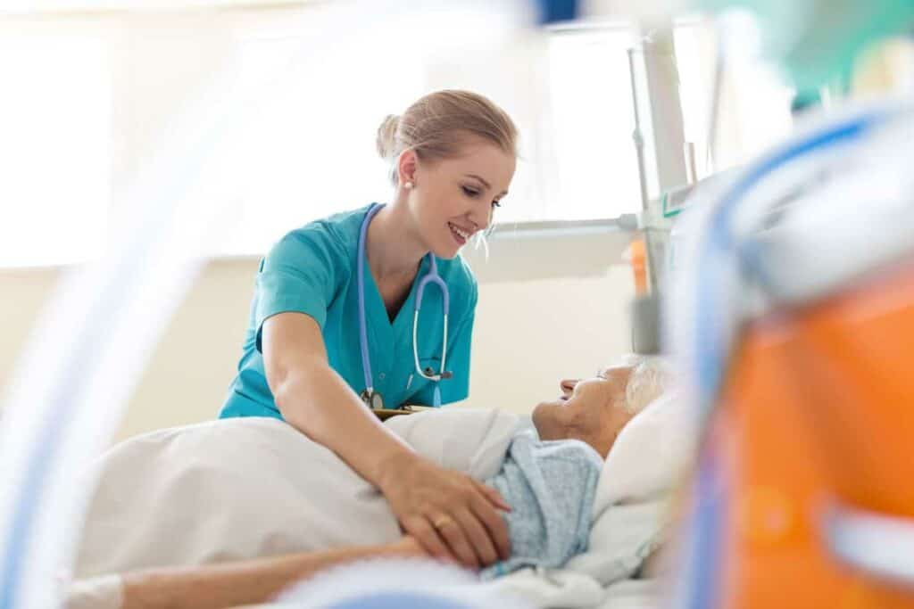 pain palliative care - a nurse taking care of a senior in bed.