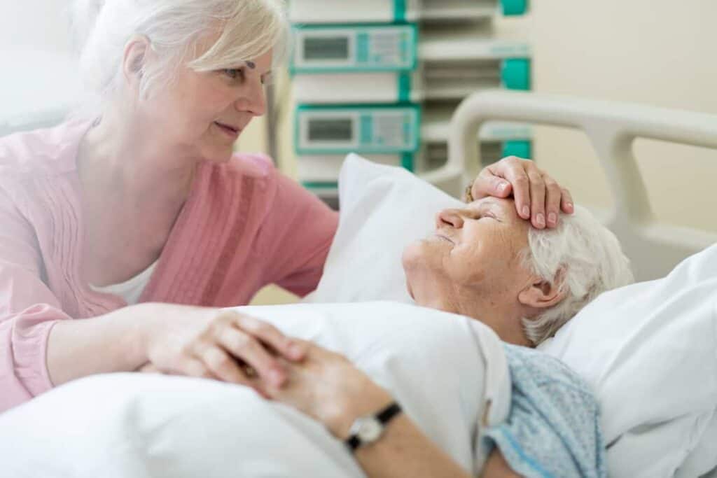 palliative care and pain management - a daughter visiting her ill mother at a hospital.