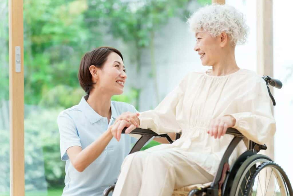 qualifications for palliative care - palliative caregiver smiling at elderly woman