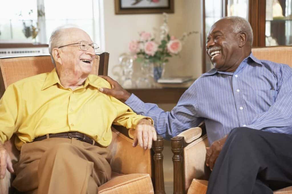 Two senior men laughing and relaxing at a senior living residence in Indian Hills, NV
