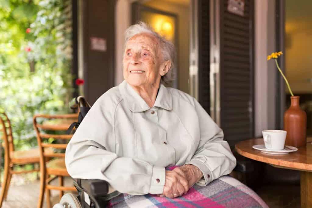 A smiling portrait of a senior woman on a wheelchair - home health agency.