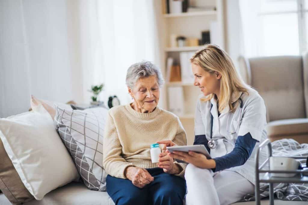 Caregiver helping a senior woman take her medication | Pros and cons of residential care in Reno and Minden
