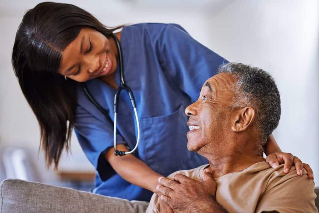 a nurse reassuring an older man at a nursing home