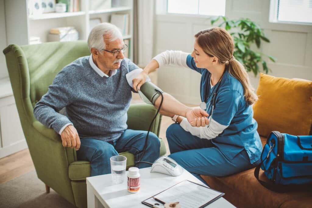 in-home nurse taking senior’s blood pressure