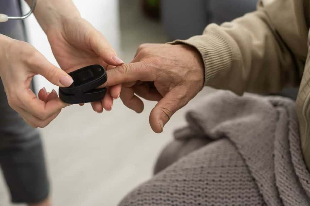 palliative care specialist using oximeter on patient’s finger