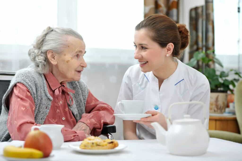 A caregiver serving a senior lunch - home health care Reno NV