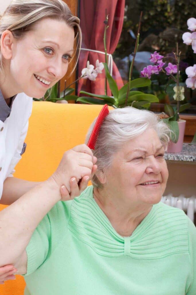 A caregiver helping a senior woman comb her hair - Nevada home care licensing