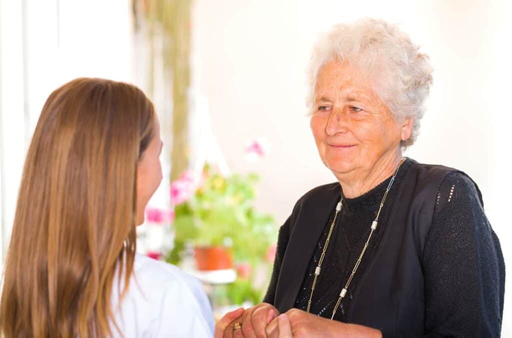 A caregiver holding a senior woman’s hand - Nevada home care