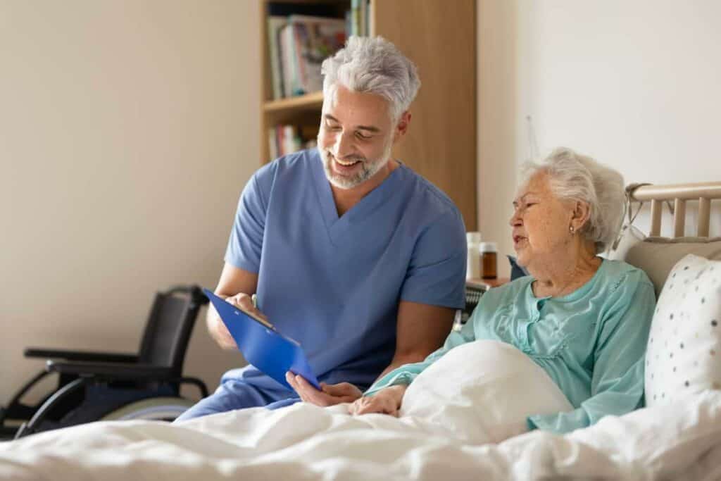 A male caregiver doing a regular home checkup on a senior patient.
