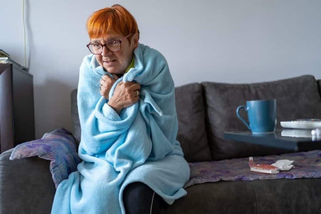 an older woman feeling cold as she starts exhibiting signs of impending death