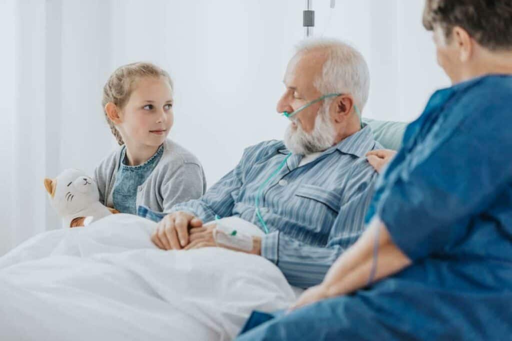 a grandfather spending time with his granddaughter as he receives care at the end of illness
