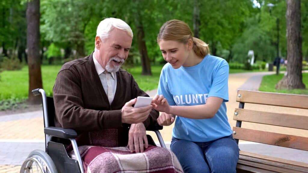 volunteer helping a hospice care patient with online resources about their medical illness