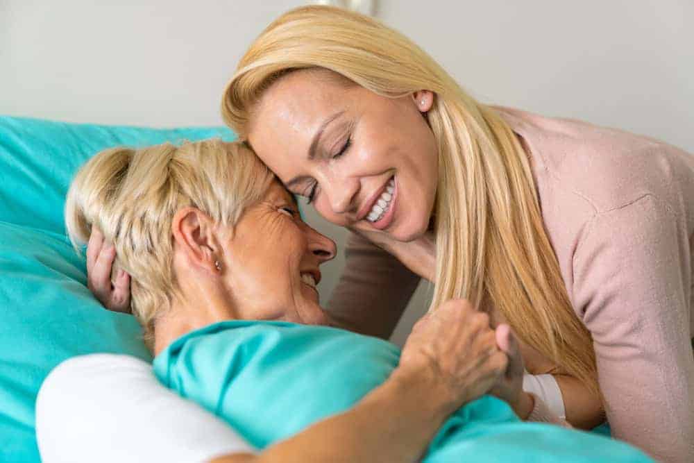 A daughter hugging her senior mother.| hospice