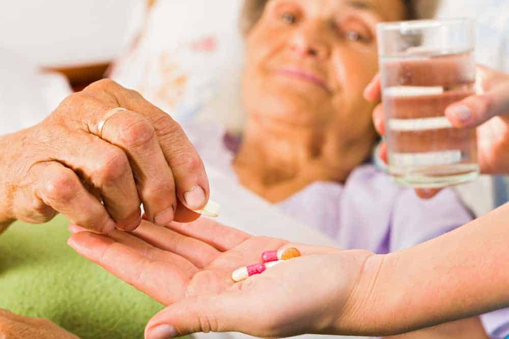 an elderly lady receiving pain relief medication at an assisted living facility