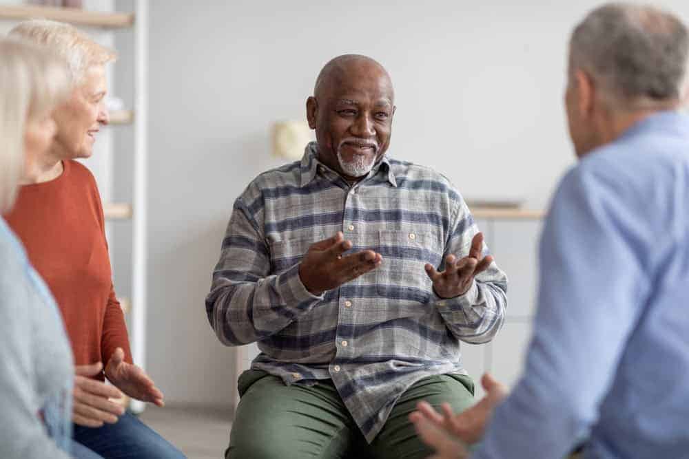 Black senior expressing his emotional need to leave a legacy behind in a group therapy session | goal of hospice