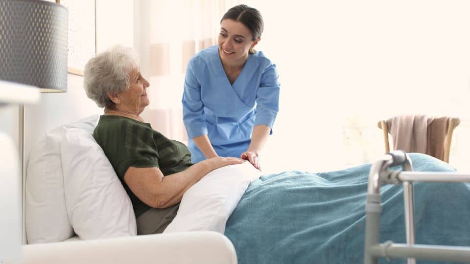 A caregiver taking care of a senior patient in her home.