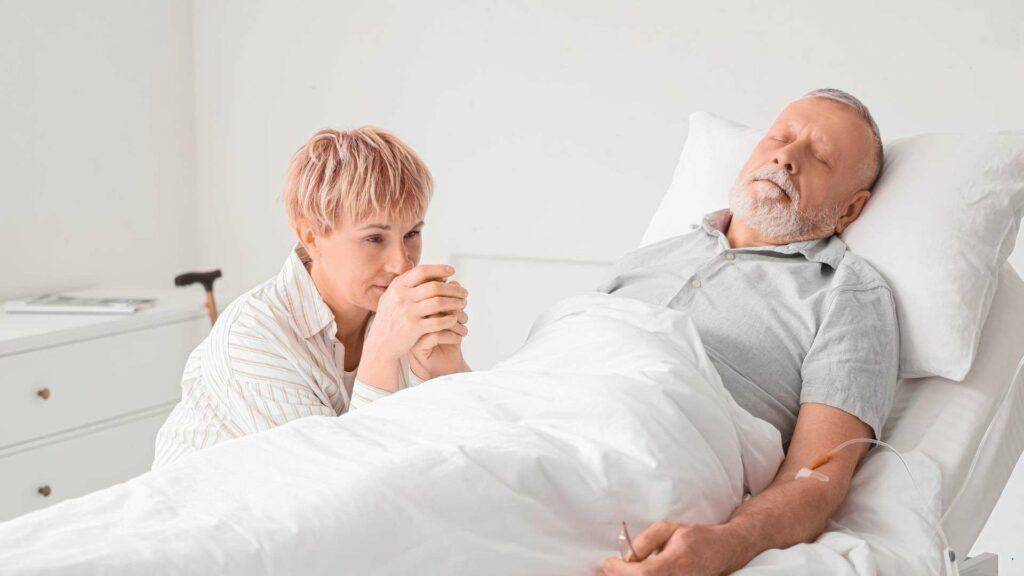 family member holding the hand of the patient and supporting him