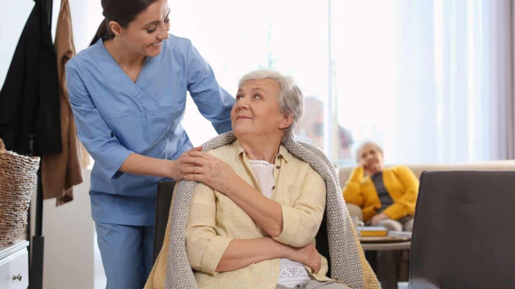 Caregiver holding the hand of her terminally ill patient for emotional support