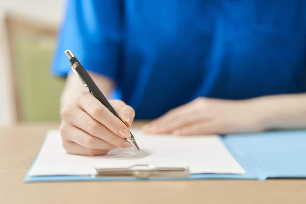 A writing hand of a physical therapist