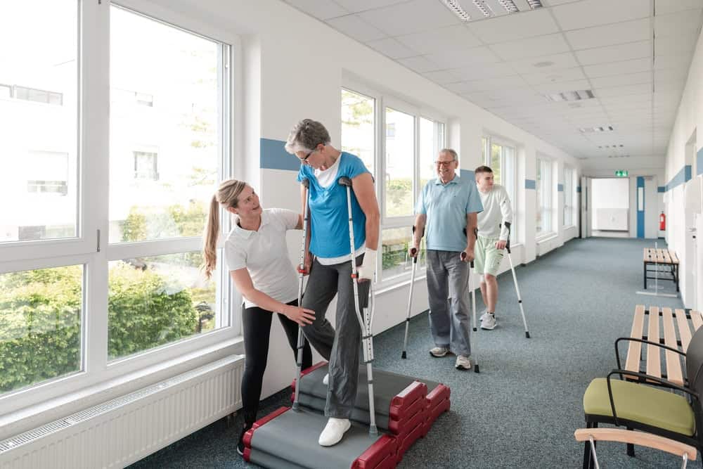 A physical therapist teaching seniors how to walk again