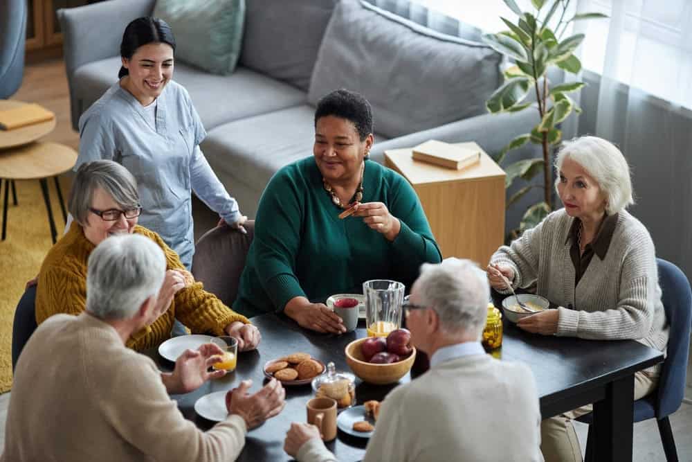 A physical therapist having a good time with seniors in a retirement home