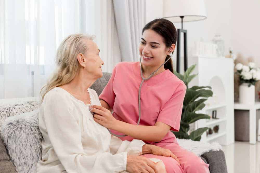 a young nurse checking out a resident at a memory care home for seniors