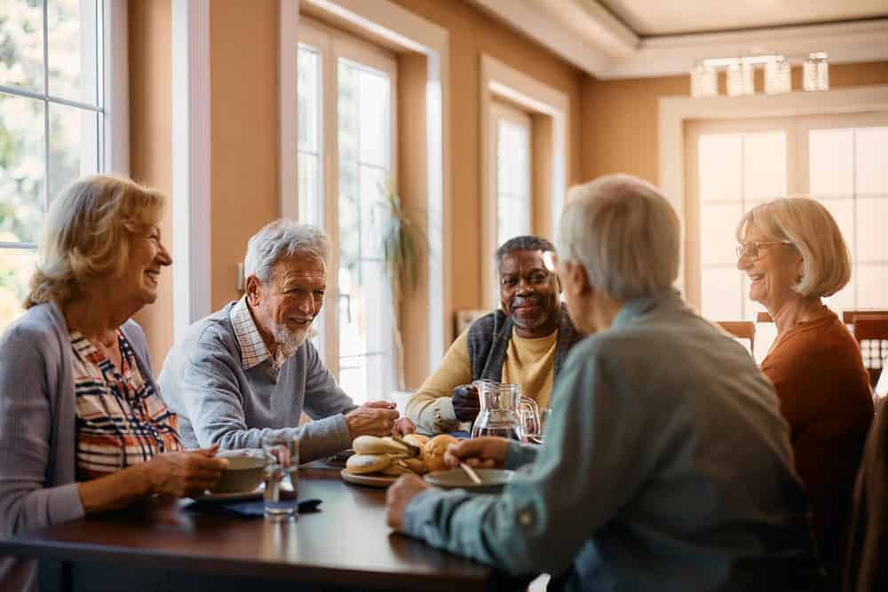 a group of seniors spending quality time together after receiving care in an assisted living home