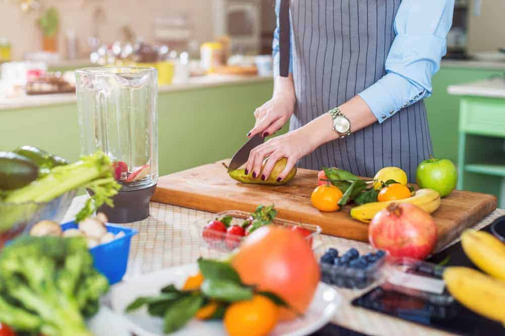 a caregiver helping with meal preparation in memory care for seniors home