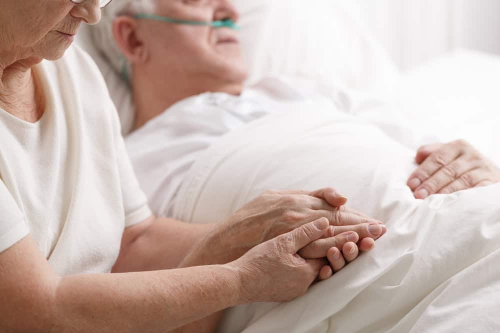 deciding between memory care and nursing homes - a sick elderly man in bed