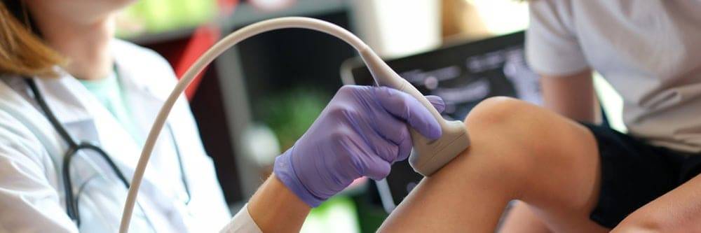 an orthopedic doctor helping with the treatment of a young girl