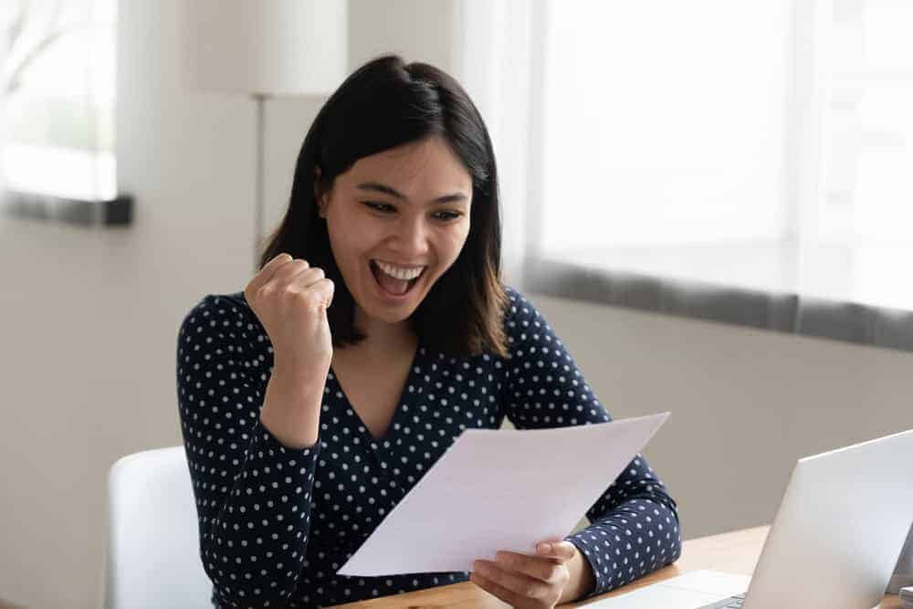 an amazed young lady after receiving her PT school admission letter