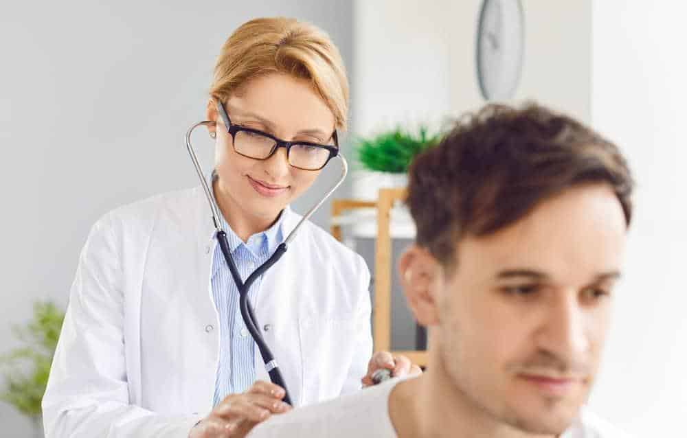 a pulmonary specialist listening to a patient’s breathing pattern