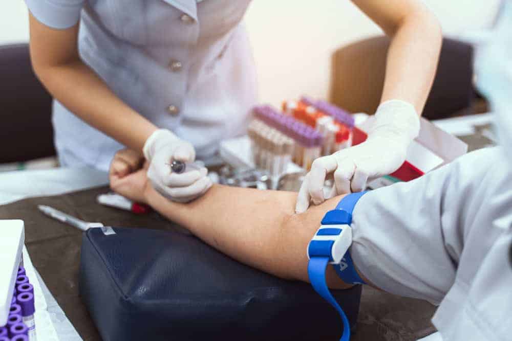 A nurse taking a blood sample from the patient.