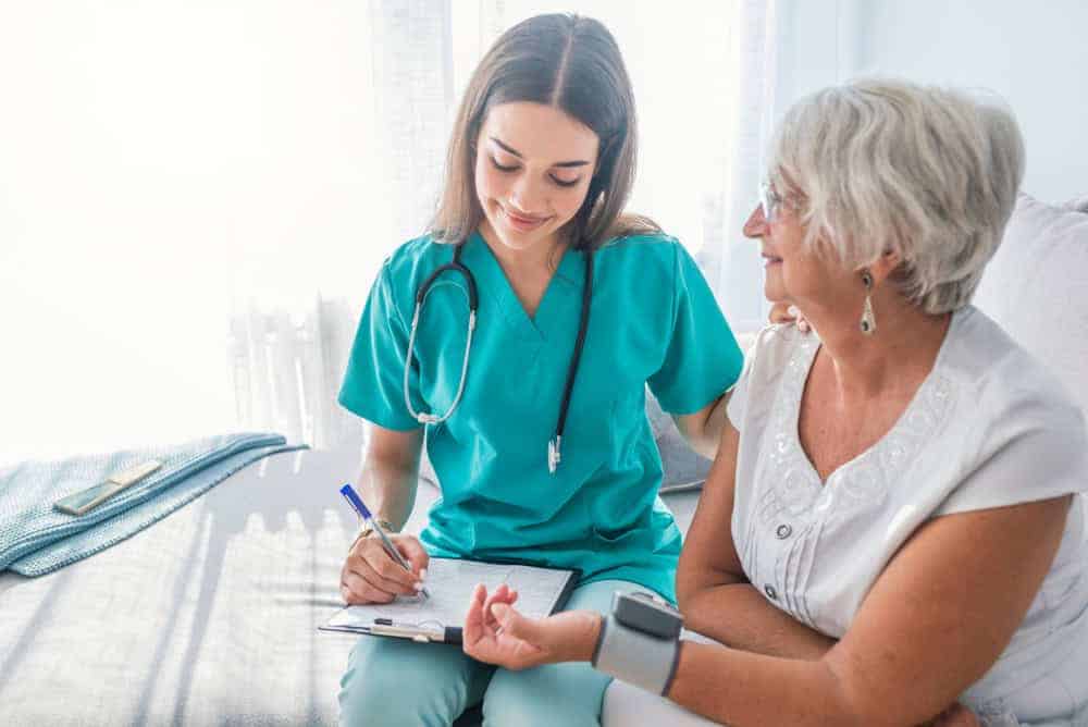 A nurse measuring the vitals of a senior woman at home