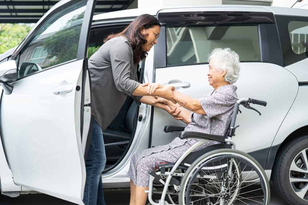 a relative helping a senior loved one with transportation to their physiotherapy sessions