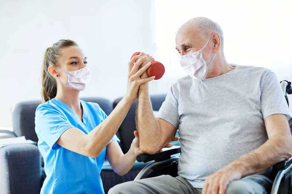 A female physical therapist guiding a senior man during exercise. | physical therapy services