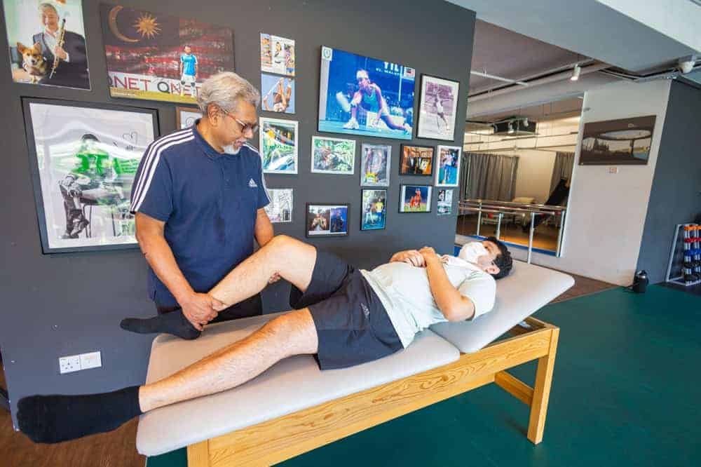 A physical therapist massaging the knee of a patient