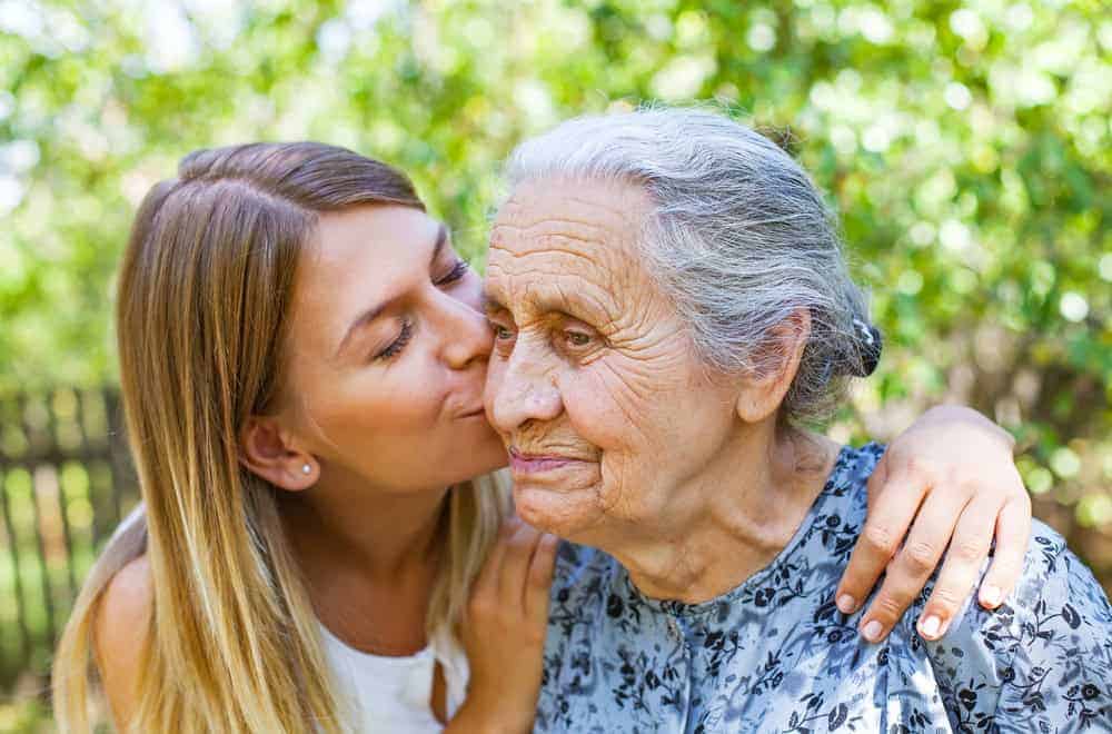 Alzheimer’s disease affects both patients and family - daughter kissing her grandma