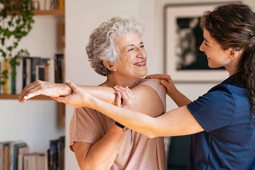 happy senior woman carrying out flexibility exercises at home