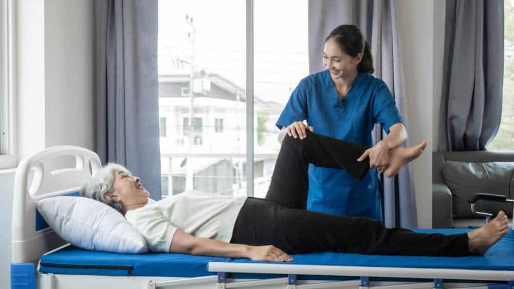 senior woman lying on the table working with a female therapist