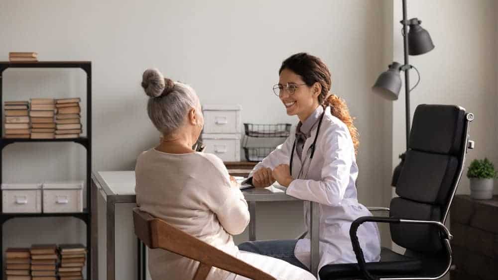 A senior woman talking to her primary doctor about therapy referral.