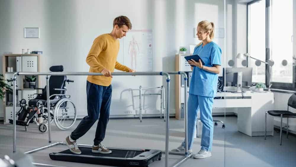 a physiotherapist helping a patient with exercising, one way to guarantee his quick recovery