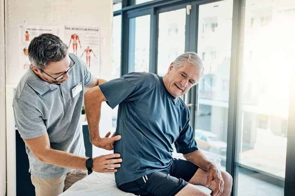 a neurological PT working on a patient’s posture realignment