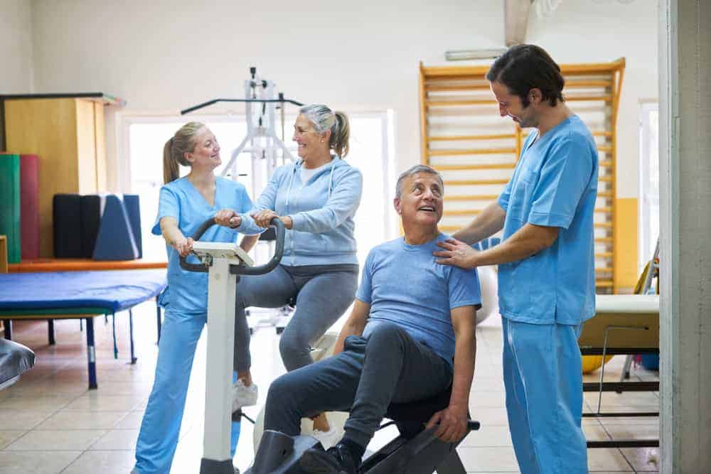 Sports therapist assisting a senior man and a woman