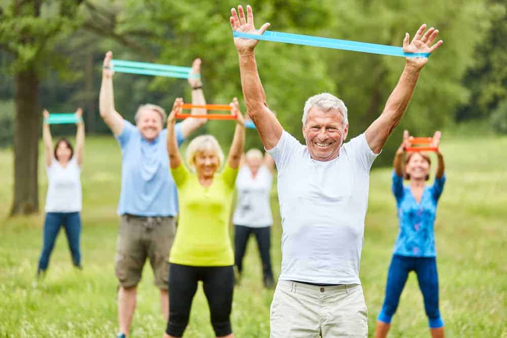 Seniors doing fitness exercises using stretch bands | physical therapists