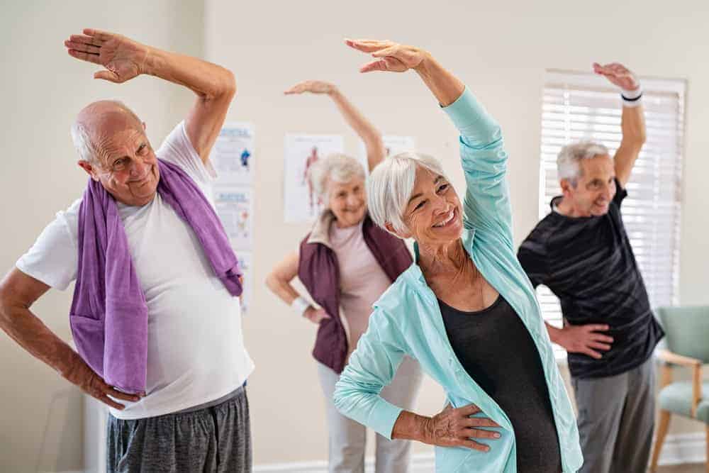 A group of seniors at a retirement home doing their morning exercise routine