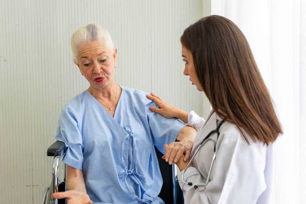 A Nevada caregiver reassuring an older woman during a hospital visit