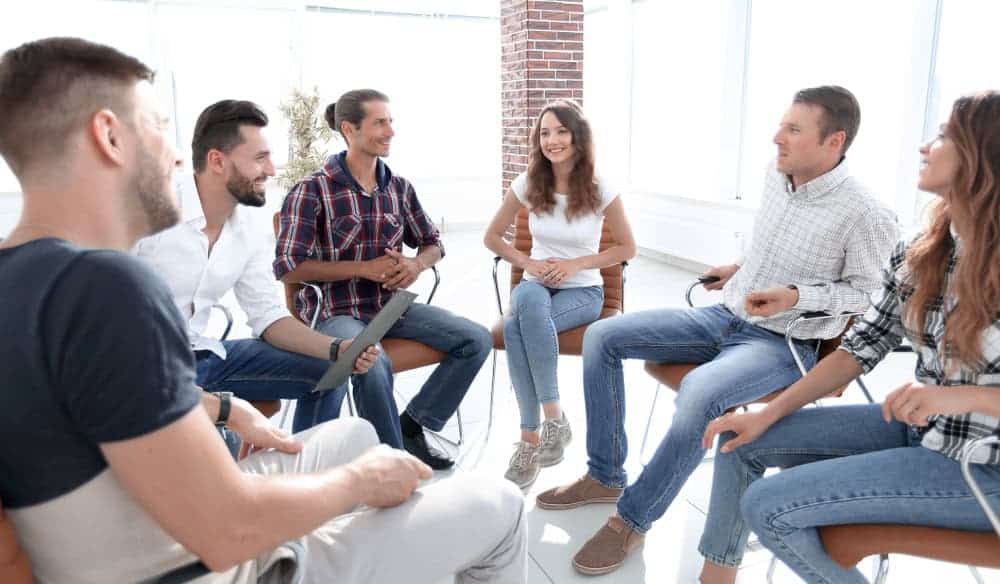 A group of caregivers discussing why caregivers quit during their support group meeting