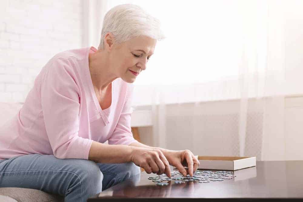 Senior woman arranging puzzles - activities for seniors during quarantine