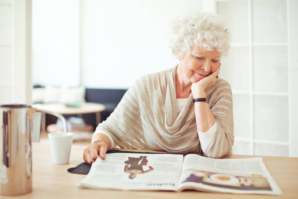 Senior woman reading a magazine - magazines for retirees